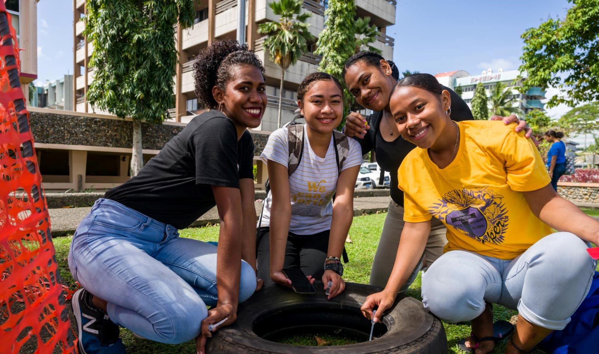 Four adolescent girls sit next to a mosquito larvae collection site in Fiji